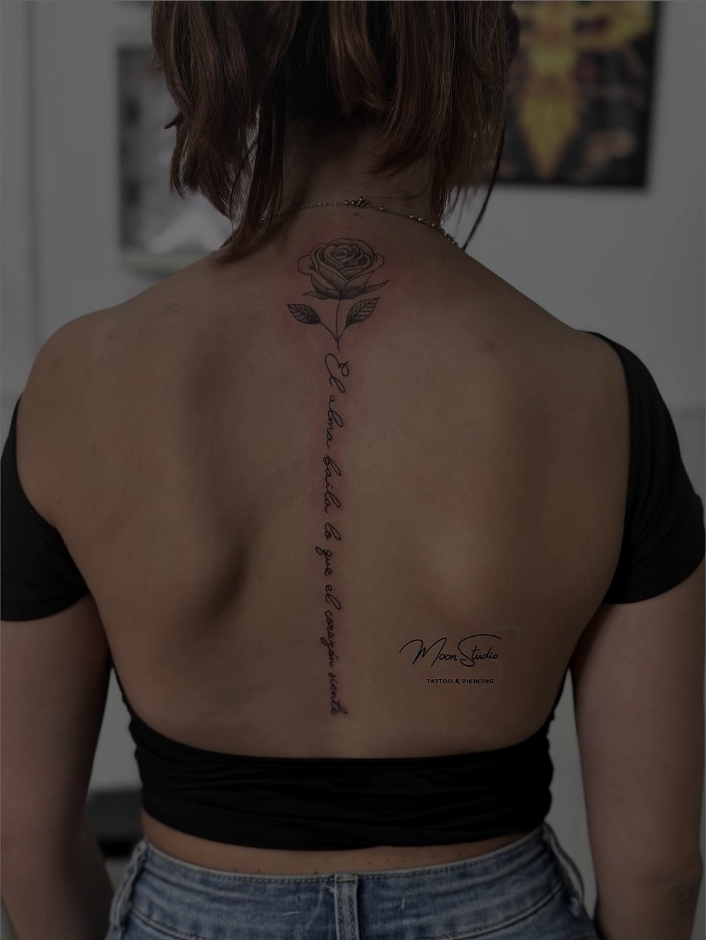 Tatuaje de rosa y lettering fine-line en la espalda, realizado en Moon Studio